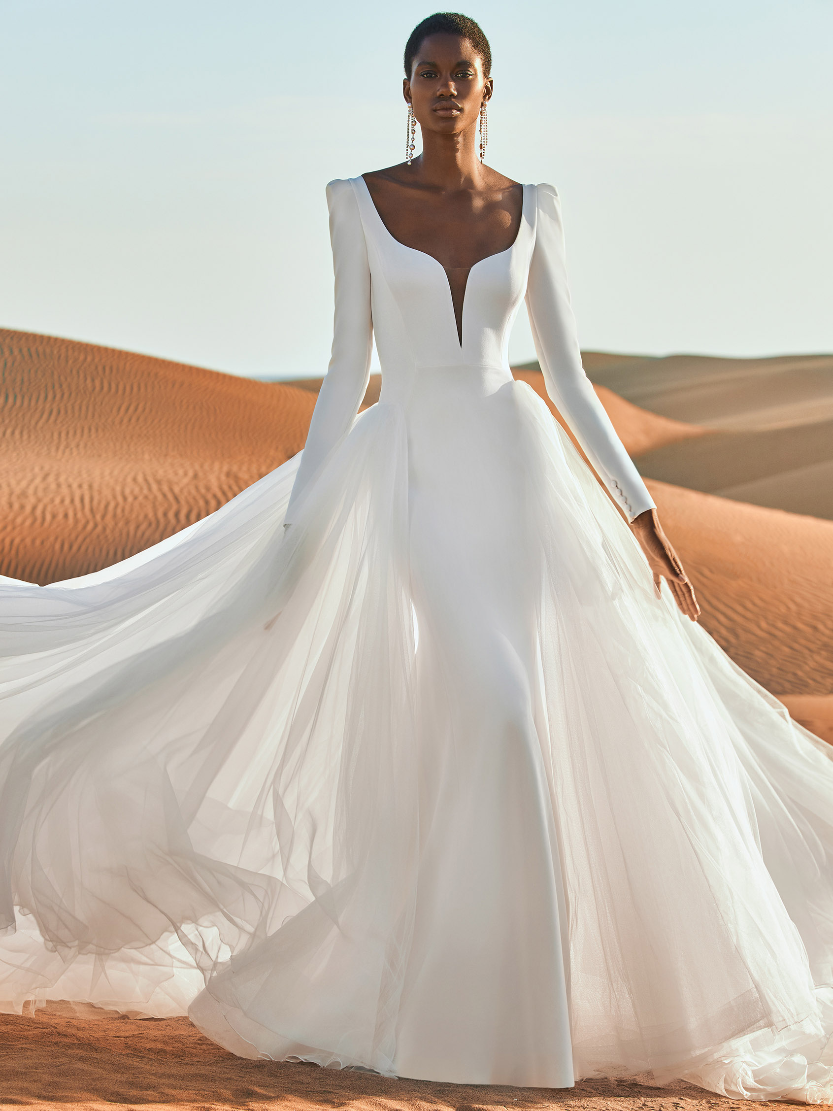 Model wears Pronovias Antelope Wedding Dress NEW SEASON stunner with long sleeves and ow back this fitted plain crepe bridal gown is fabulous